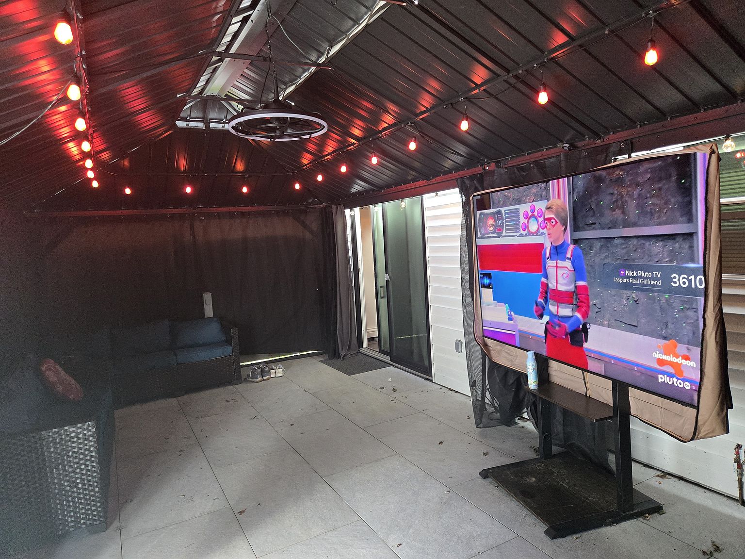 Covered patio with television and lighting